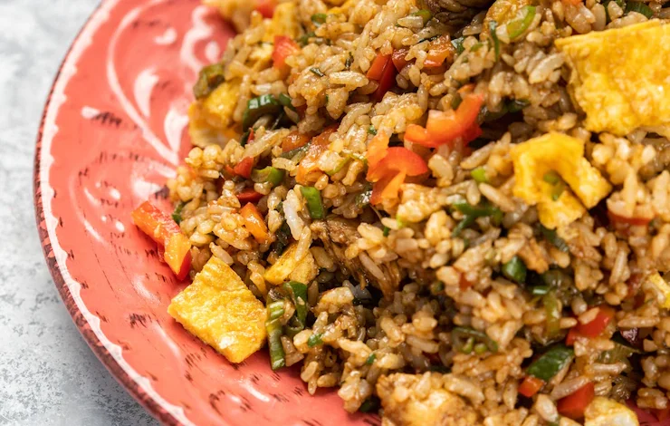 Primer plano de un delicioso arroz cocido con verduras y salsa en un plato sobre la mesa festival 'Montería me sabe a arroz'